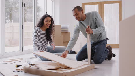 pareja en una nueva casa el día de la mudanza armando muebles de autoensamblaje