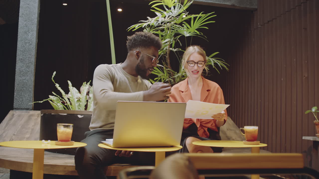 Colleagues Working on Project in Modern Cafe