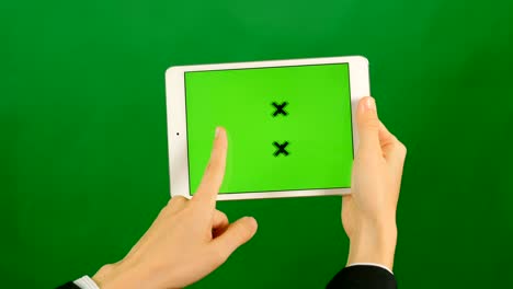 mujer de negocios usando una tableta de pantalla verde en blanco sobre un fondo verde.