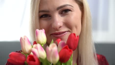 beautiful young blonde woman with pink tulips