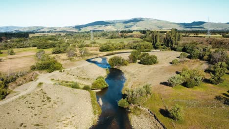 aerial shot of a small creek in the countryside of new zealand