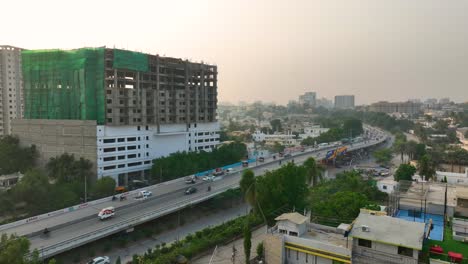 aerial shot of busy shaheed-e-millat road surrounded by buildings in evening at karachi in pakistan