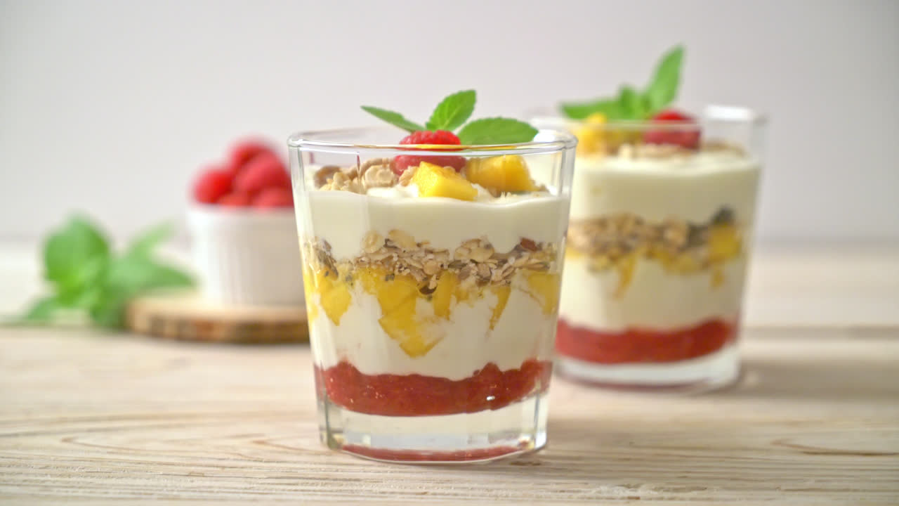 mango fresco casero y frambuesa fresca con yogur y granola - estilo de comida saludable