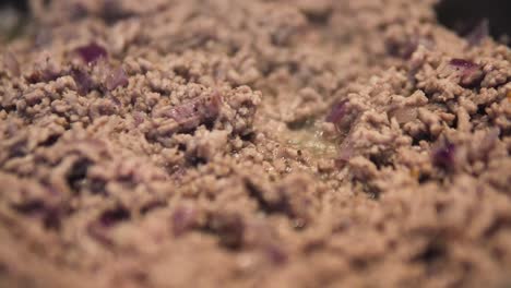 cooking minced meat with onions in pan, close up, sauce bolognese