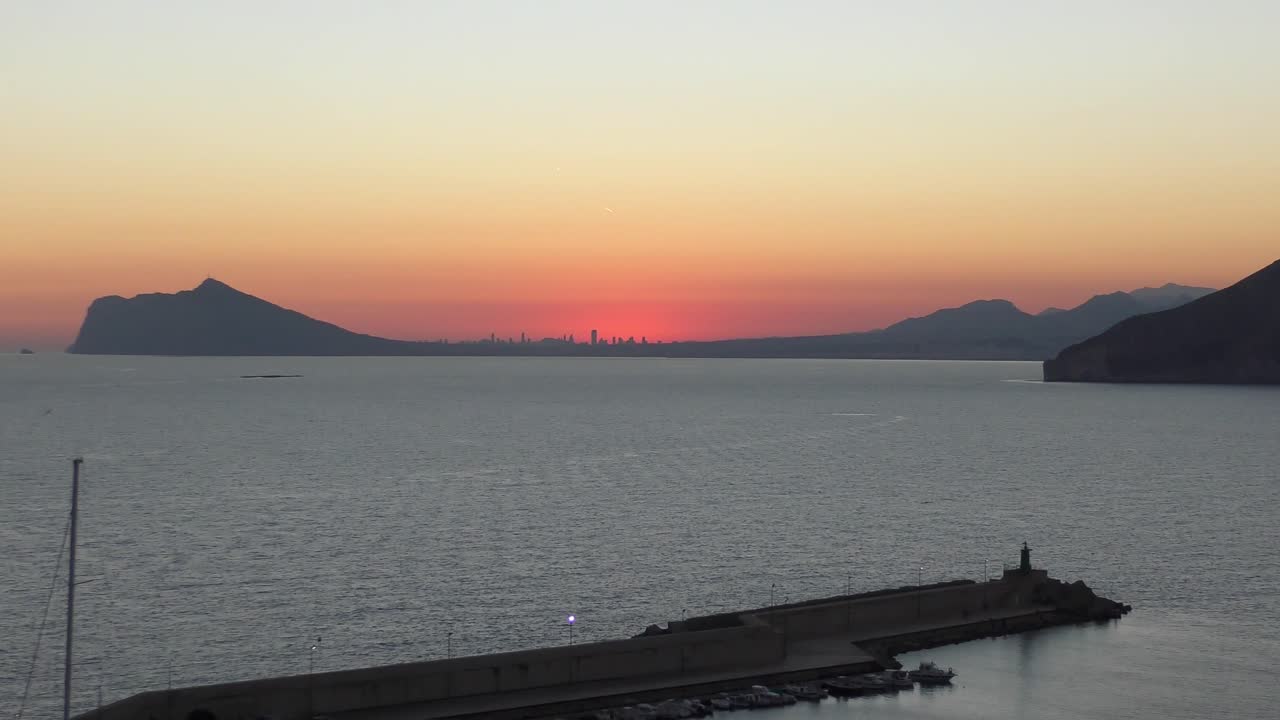 피나 데 이파크 (pina de ifaque) 에서 아오르는 태양의 마지막 광선에 싸인 베니도름 (benidorm) 의 스카이 라인을 바라보는 스페인 칼페