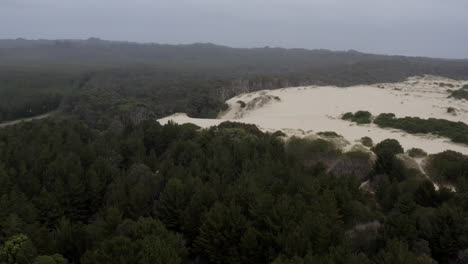 Aerial:-Drone-flying-towards-a-sand-dune-on-the-west-coast-of-Tasmania-near-Strahan