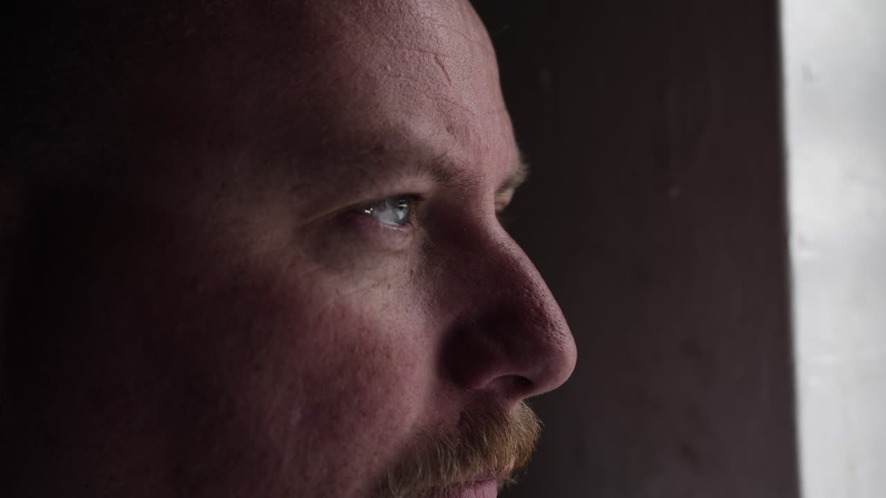 hombre de aspecto serio profundamente en pensamiento y contemplación mirando hacia afuera