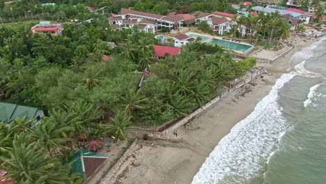 Toma-Aérea-Relajante-De-Playa,-Arena-Arenosa-Y-Paisaje-De-Estructura-De-Vista-Al-Mar-En-Puerto-Galera,-Filipinas