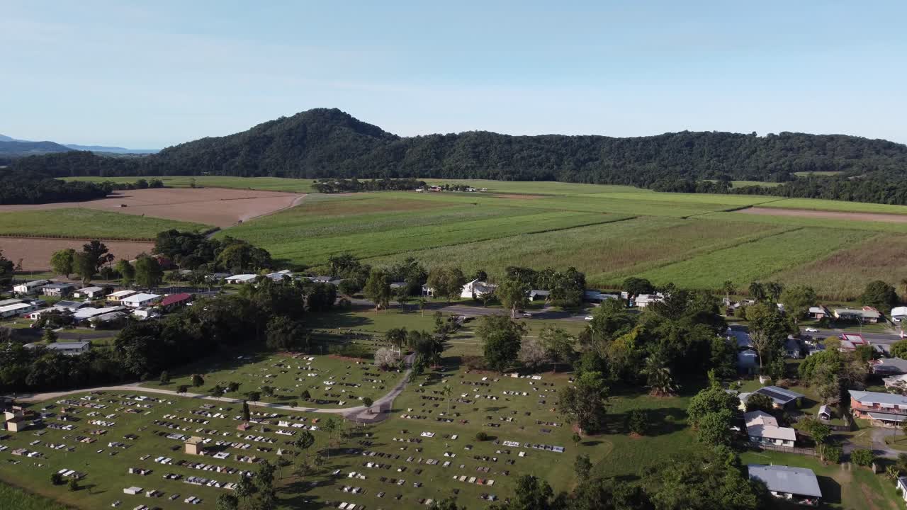 4K Aerial view of the town cemetery and a sugar cane plantation in a small rural town in North Queensland, Australia