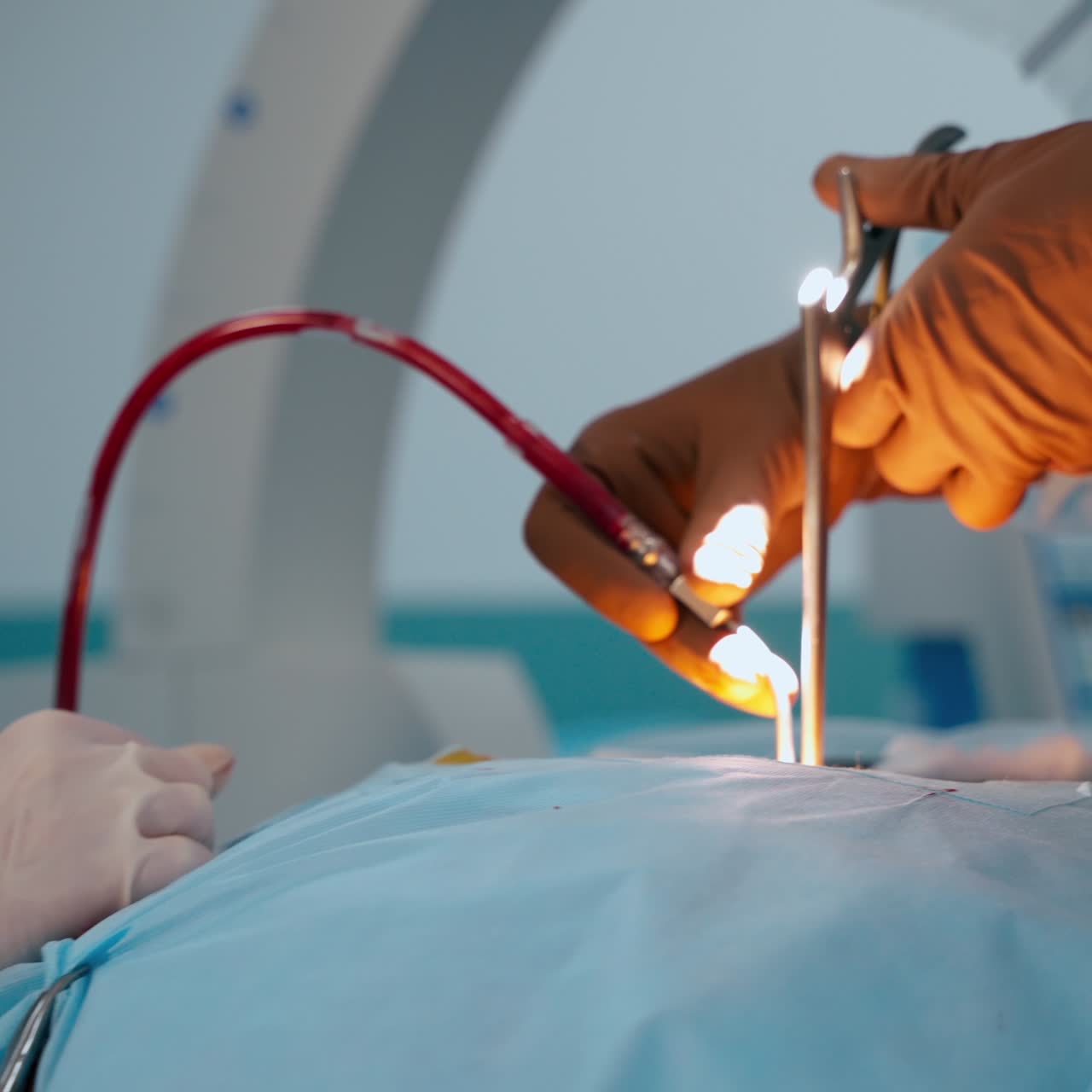 Operation process to a patient in clinic. Surgeon performing a surgery while looking into the microscope. Female nurse helps the doctor.