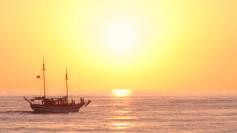 a boat sailing across choppy water on the open sea at sunset