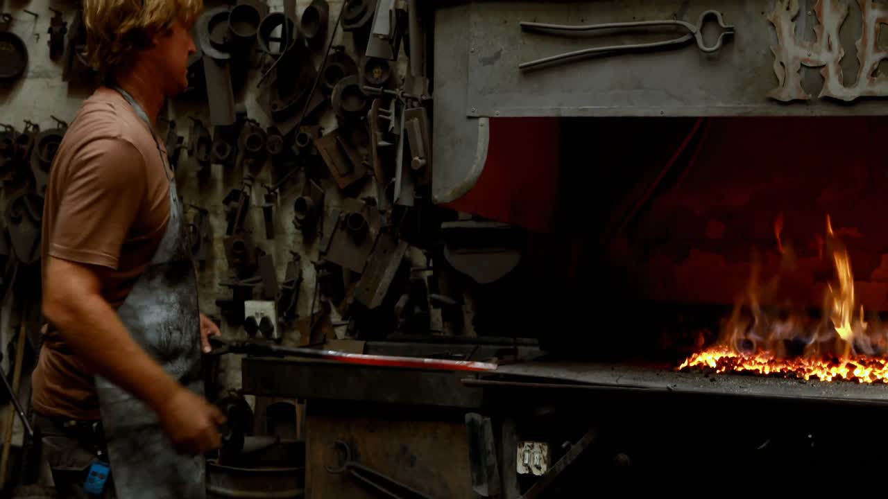 herrero martillando una barra de metal caliente 4k