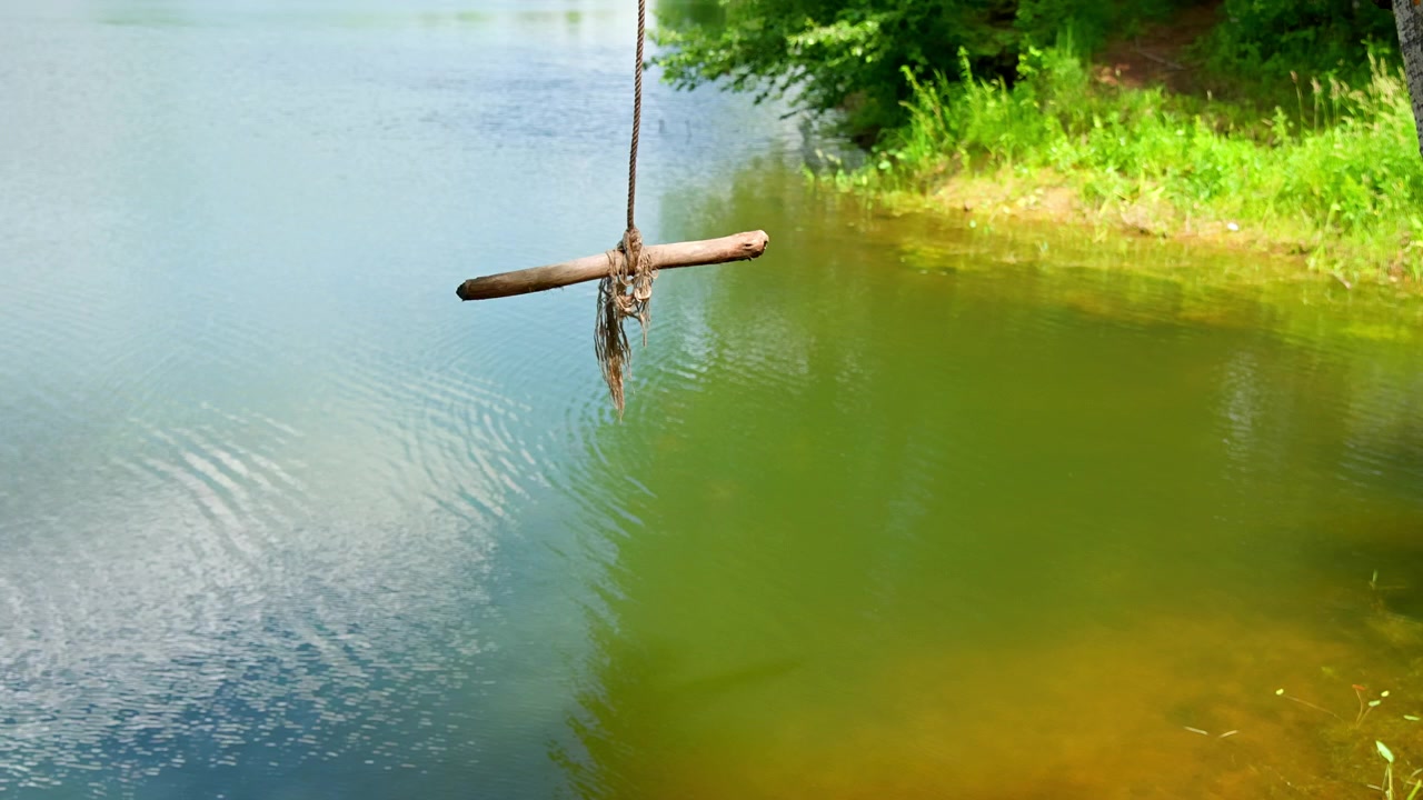 Rustikale Seilschaukel über ruhigem Seewasser