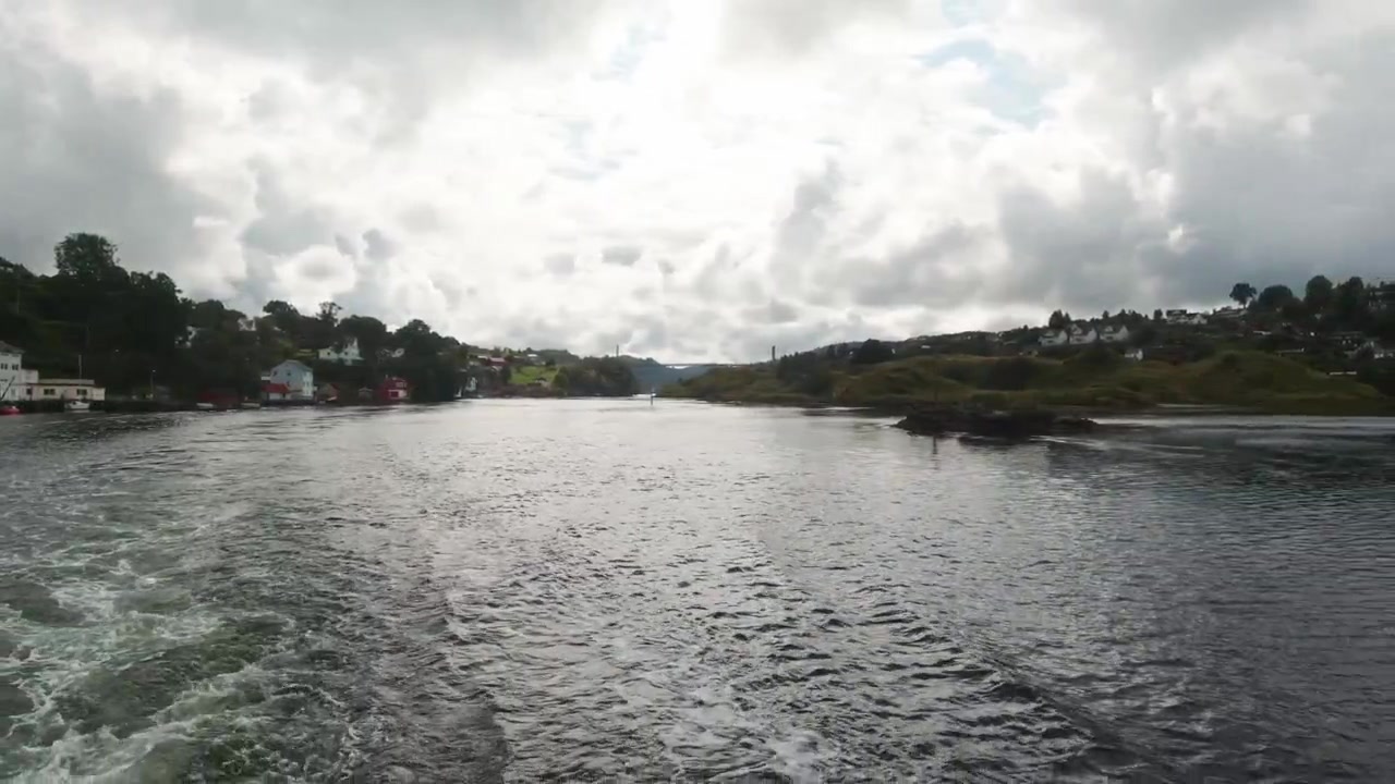 Naturskønne udsigter fra agterstavnen på en bådtur i Bergen, Norge med overskyet himmel