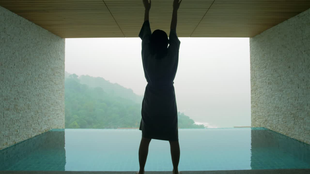 The soft and blur focus of Asia women standing and exercise on the private poolside in the resort on vacation time