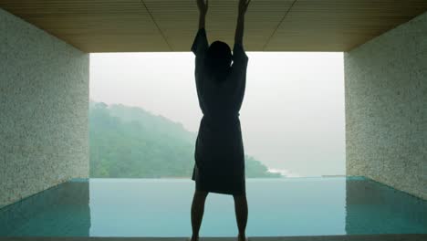 The-soft-and-blur-focus-of-Asia-women-standing-and-exercise-on-the-private-poolside-in-the-resort-on-vacation-time