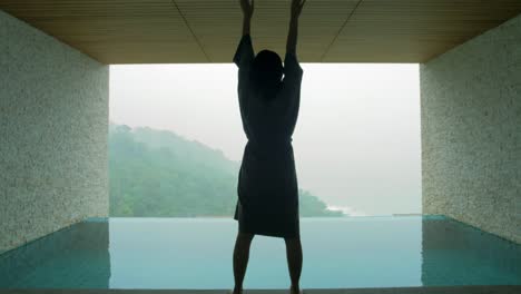 the soft and blur focus of asia women standing and exercise on the private poolside in the resort on vacation time