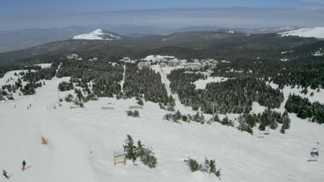 aerial view of a bustling ski resort on a snowy mountain