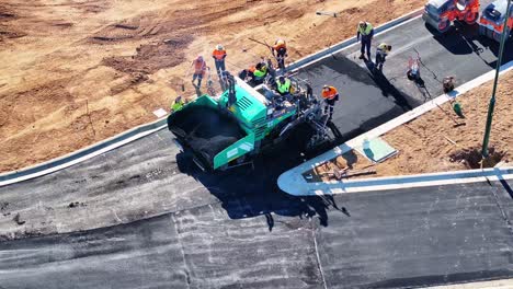 aerial view of construction crew paving a road with an asphalt paver