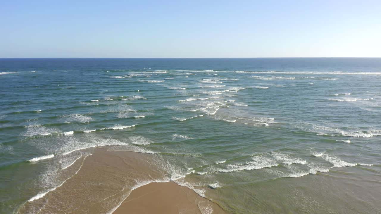Drone advances over a narrowing sandbank as tides converge from both sides, then continues toward open sea