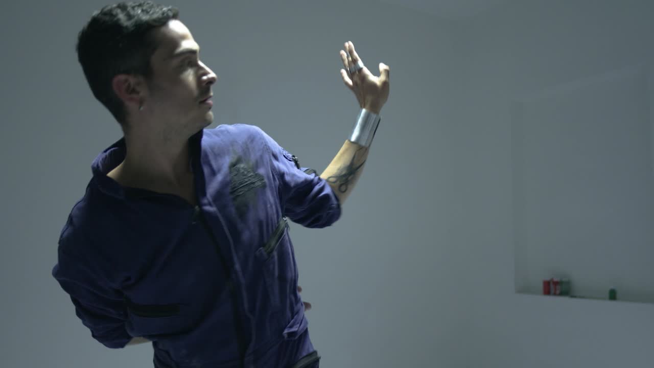 Performance artistica di un uomo che balla con movimenti freestyle espressivi.