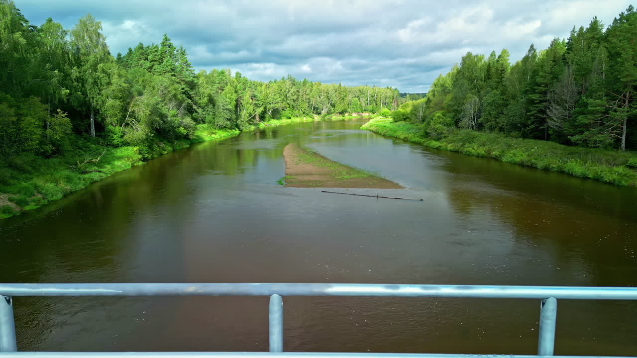 낮에는 푸른 나무 사이에 강을 가로지르는 다리에 주차된 밴