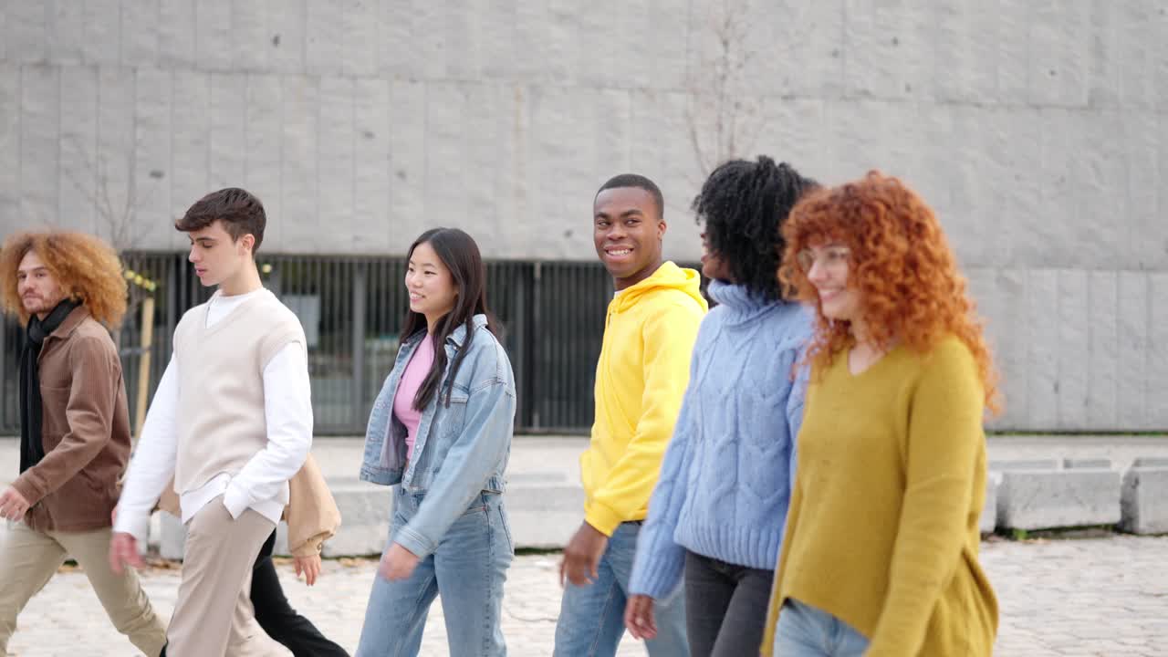 Multiracial friends smiling while strolling along the street