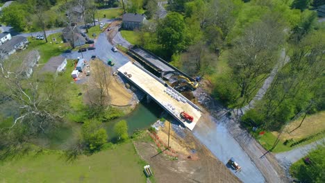 aerial view of farmlands and a bridge being replaced over a stream on a beautiful sunny day