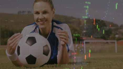 stock market data animation over smiling woman holding soccer ball on grass field