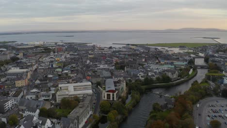 toma de descenso aéreo de la ciudad de galway durante la puesta de sol, con el río corrib