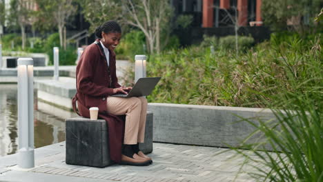 a woman working on her laptop in a city park