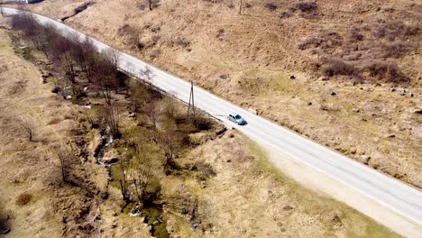 drone footage of a car passing by on the road in the mountains in romania