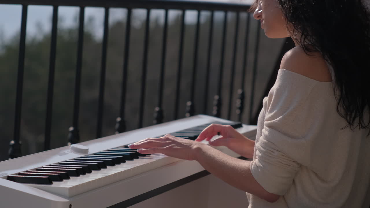 женщина играет на пианино на балконе