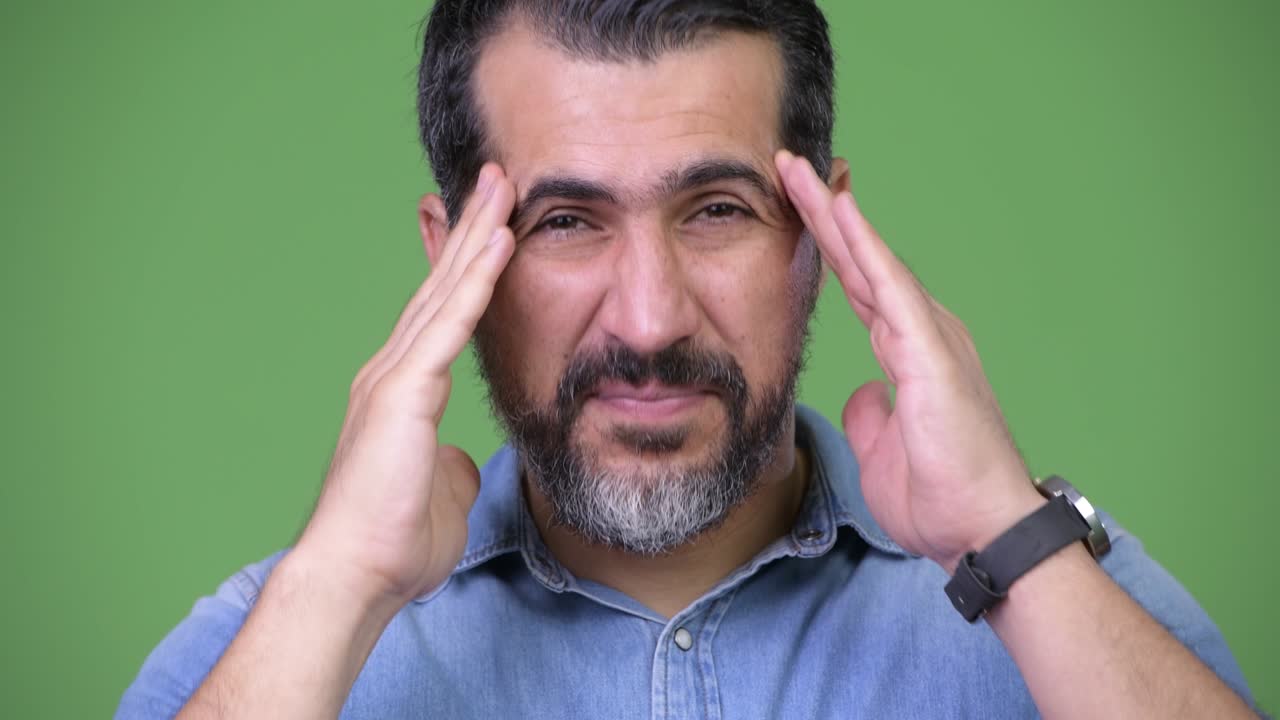 Handsome Persian bearded man having headache