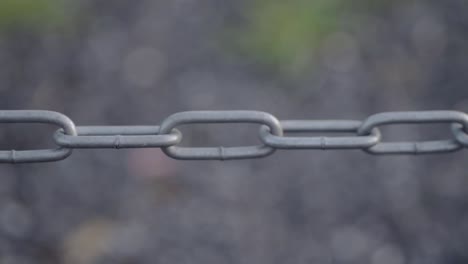 isolated strong metal chain sways in breeze