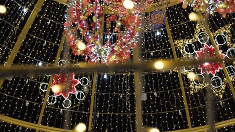 mini lighting christmas balls hanging inside the giant christmas ball - pan up shot