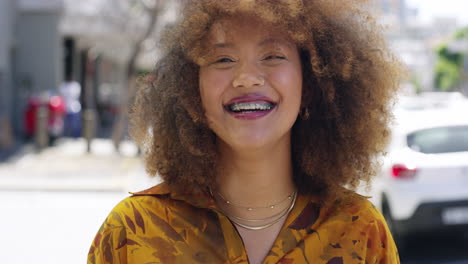 a young woman laughing while out in the city