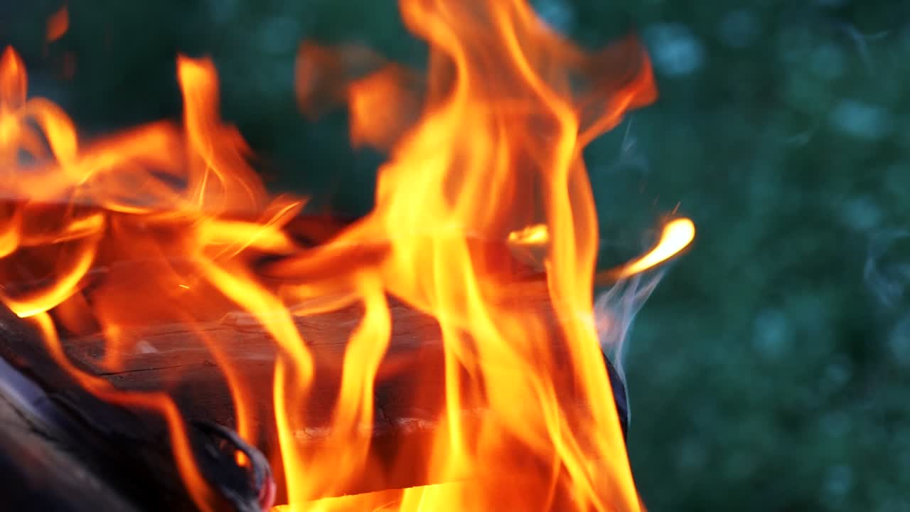 boards are smoldering and burning in the bonfire in the yard