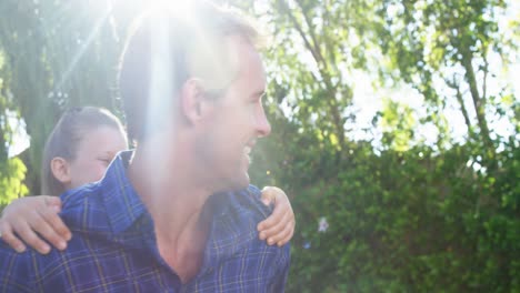 Father-giving-piggyback-to-his-daughter-in-park