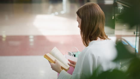 young woman intently focused with a blurred background showing a modern mall and moving elevator, subtle lighting highlights her contemplative expression