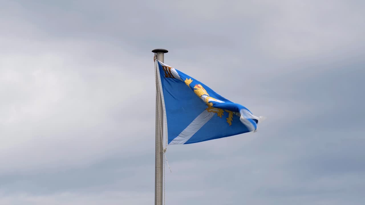 bandera escocesa del regimiento montada en un asta de bandera ondeando en un fuerte viento