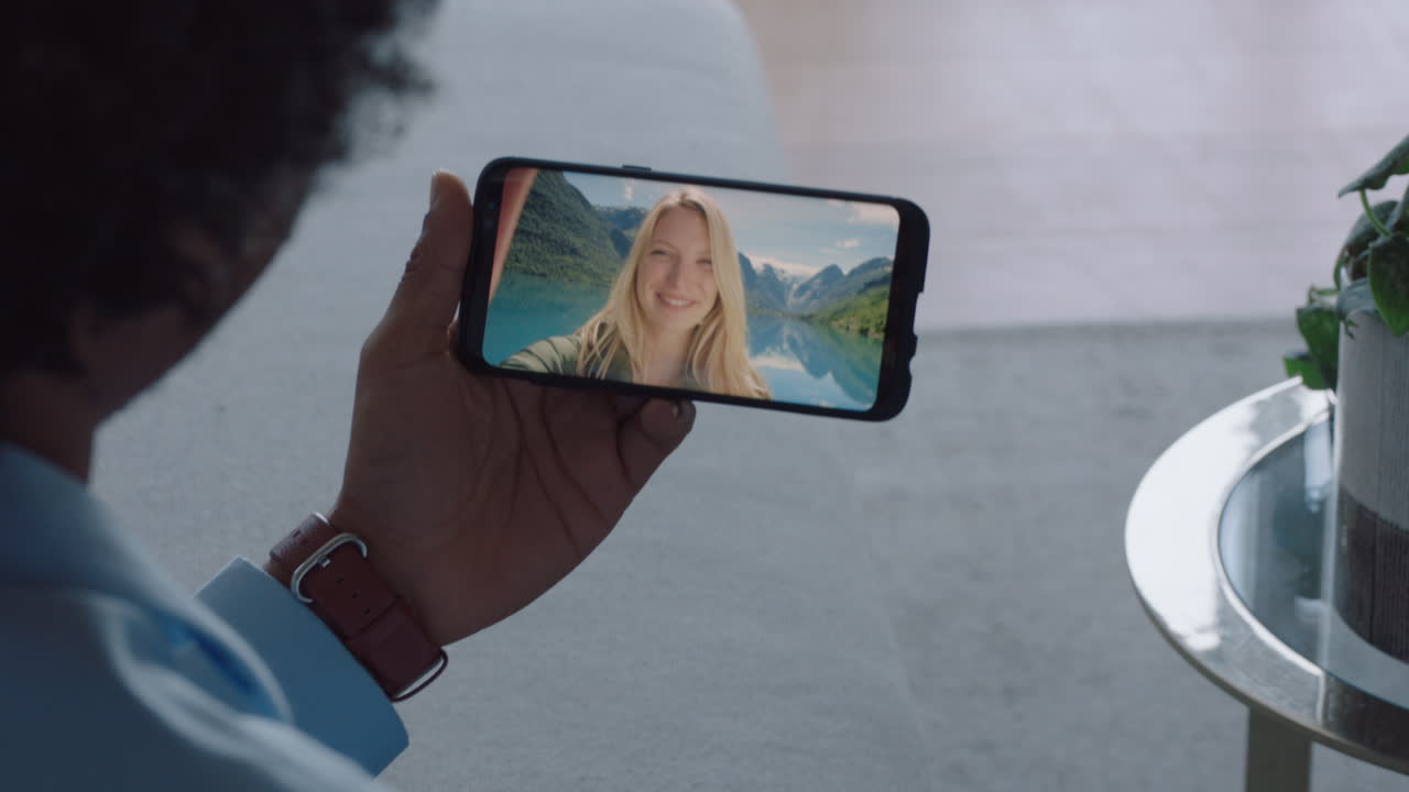 hombre joven chateando en video con su novia en el teléfono inteligente saludando con la mano mujer joven compartiendo vacaciones viaje pareja teniendo una relación a larga distancia