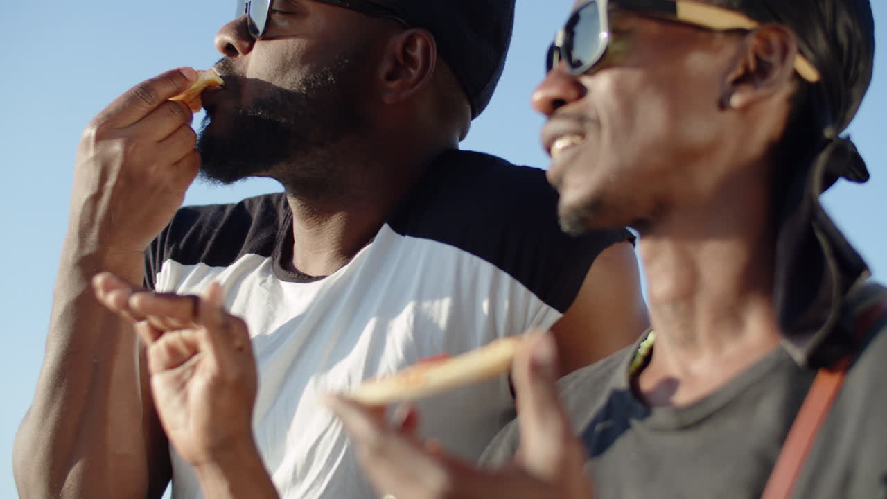 피자와 도시 경관을 즐기는 게이들의 핸드헬드 샷