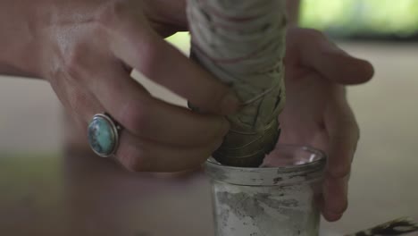 lighting sage on a small candle for a ceremony