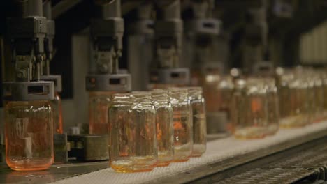 lot of glass jars in line in glass production plant, automated process