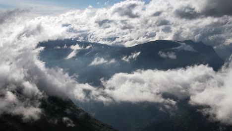 las nubes blancas se mueven lentamente y se acurrucan sobre las laderas de las montañas hardangervidda de noruega en un día soleado