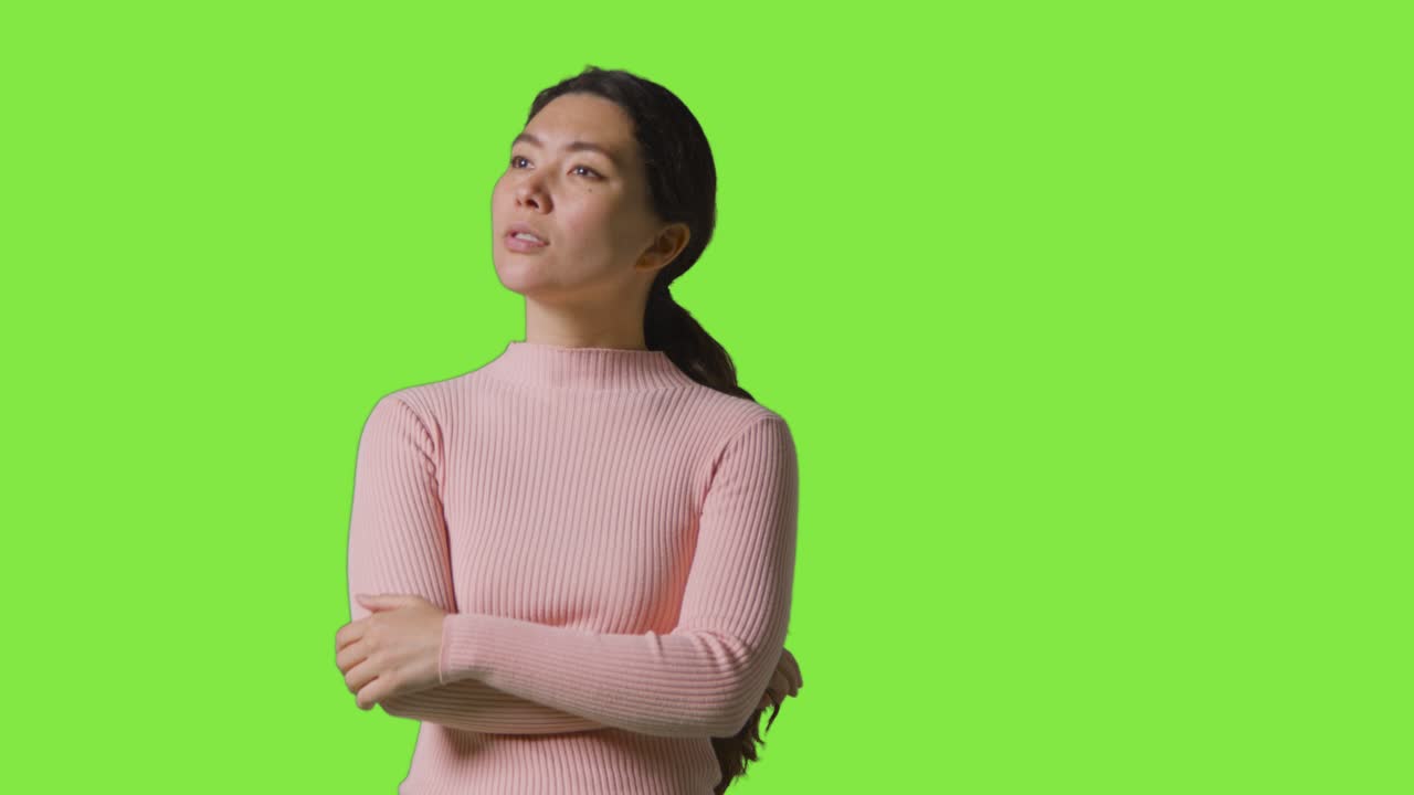 Studio Shot Of Woman With Serious Expression Looking All Around Frame Against Green Screen In VR Environment
