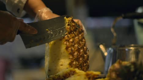 se quita la cáscara de la piña con un cuchillo de cocina, filmada en cámara lenta como primer plano