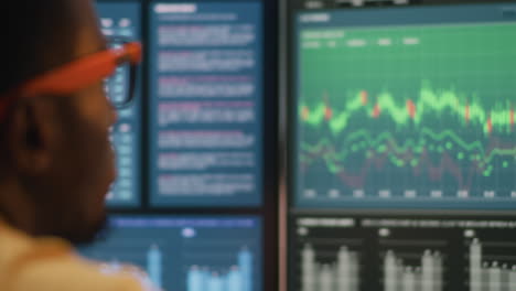 person analyzing stock market data on multiple screens