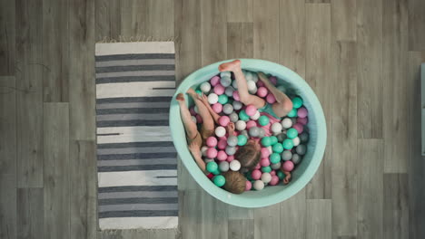 toddler boy and preschooler girl play lying in dry pool